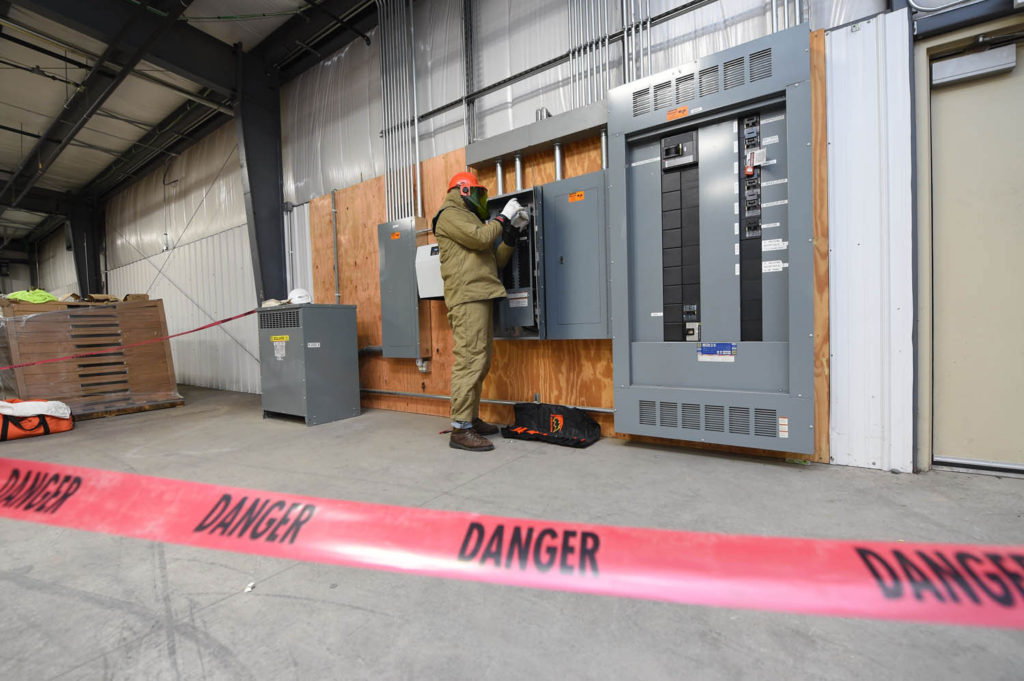 Industrial electrician working on an electrical panel